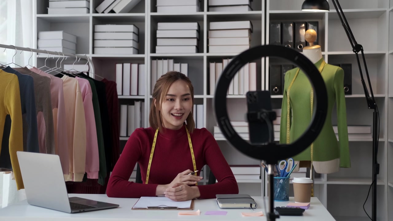 详情图-亚洲女商人在家直播卖衣服，漂亮女孩用智能手机和平板电脑录制视频。