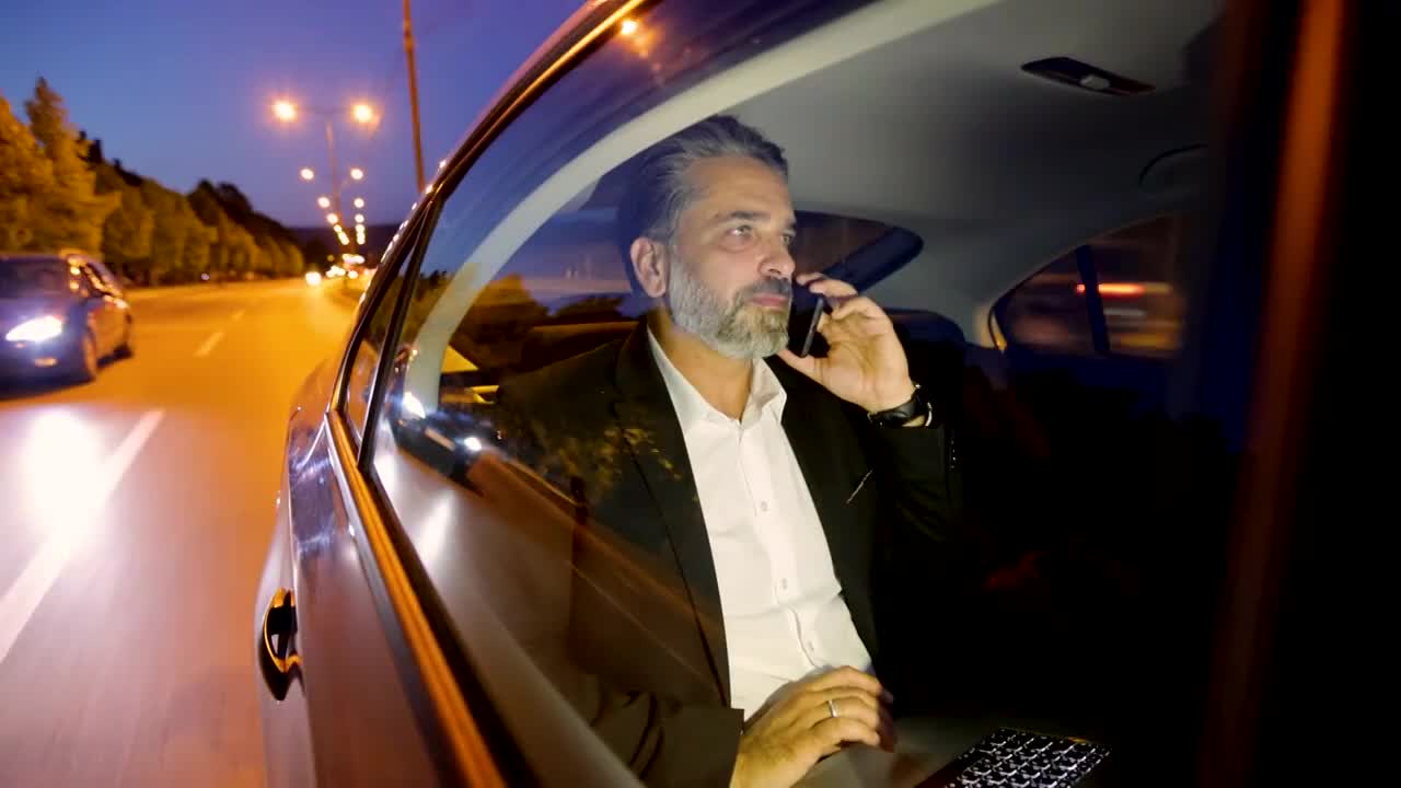 幸福成熟的商人在车里谈笑风生
