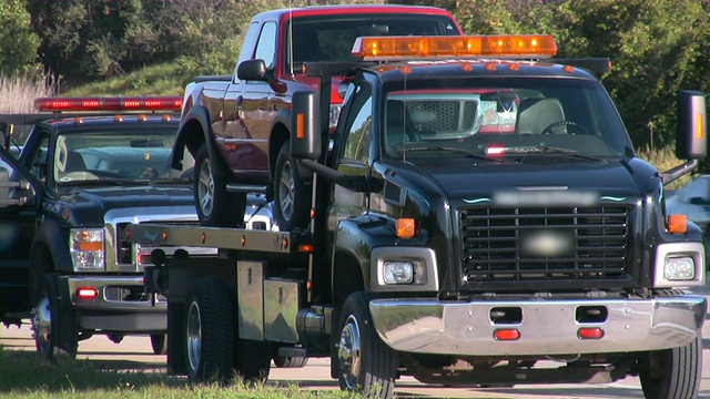 拖车拖着一辆破车。高速公路道路援助。事故。