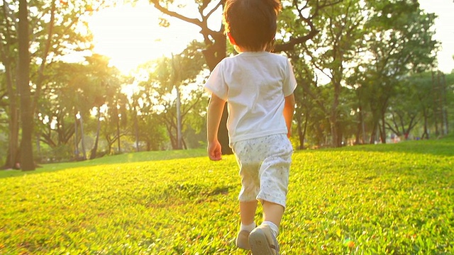 日落時(shí)分，小男孩在公園里跑步。