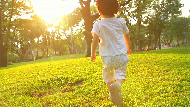 詳情圖-日落時(shí)分，小男孩在公園里跑步。