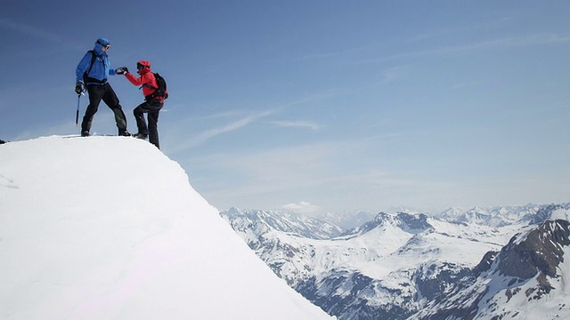 详情图-攀登者互相帮助到达白雪覆盖的山峰