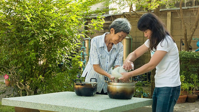 在花园里做饭的亚洲女人