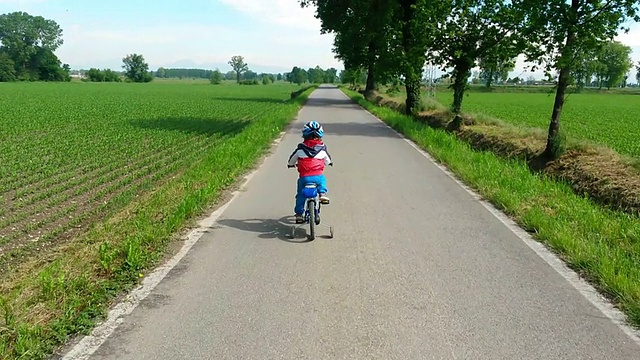 蹒跚学步的孩子正在学习骑他的新自行车