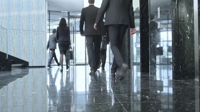 商务人士穿过大厅走出大楼
