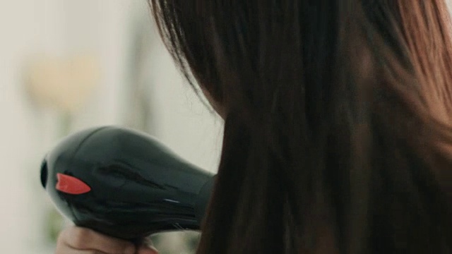 美丽的女人在吹她的头发