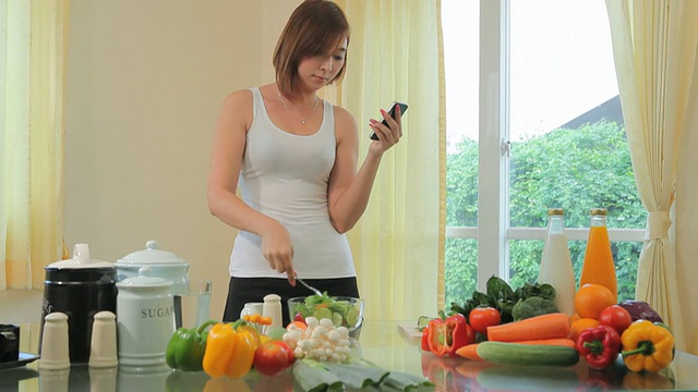 年轻女子在手机上跟踪食谱