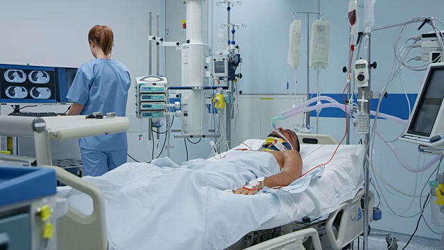 重症监护室的护士正在检查一位年轻男性病人
