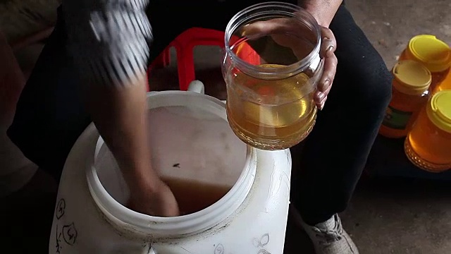 养蜂人用小瓶包装蜂蜜
