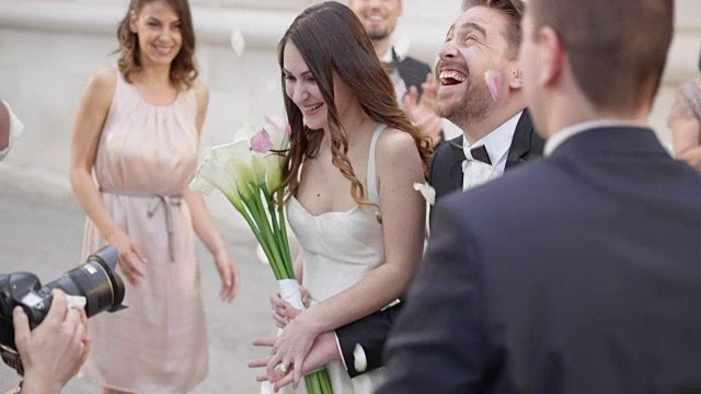 详情图-新婚夫妇在玫瑰花瓣阵雨中离开教堂