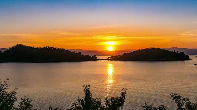 日落时湖面和两座岛屿上的绚丽天空，时光流逝