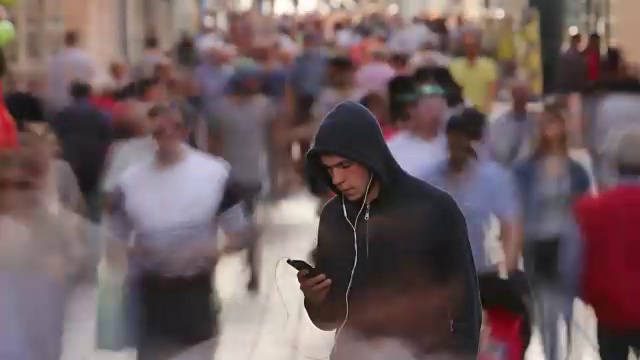 一个年轻人独自在繁忙的街道上