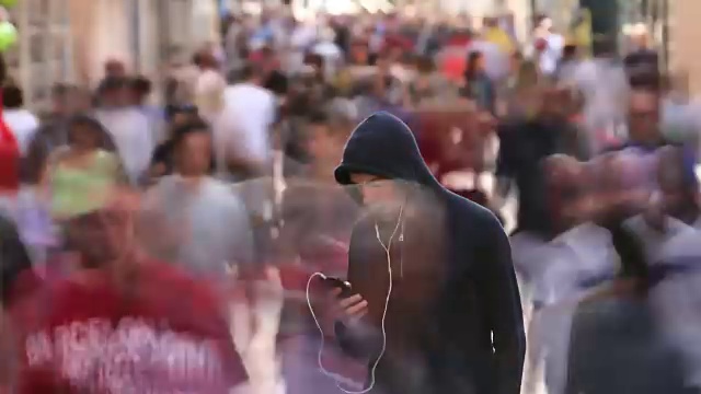 詳情圖-一個年輕人獨自在繁忙的街道上
