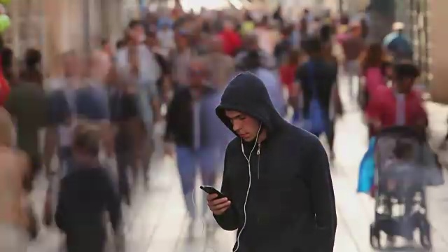 詳情圖-一個年輕人獨自在繁忙的街道上