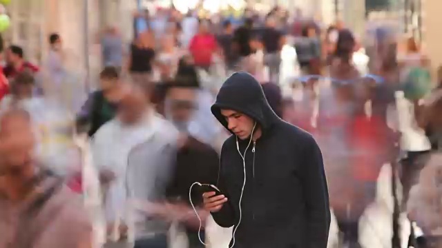 詳情圖-一個年輕人獨自在繁忙的街道上