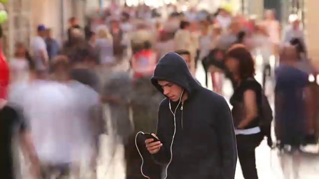 詳情圖-一個年輕人獨自在繁忙的街道上
