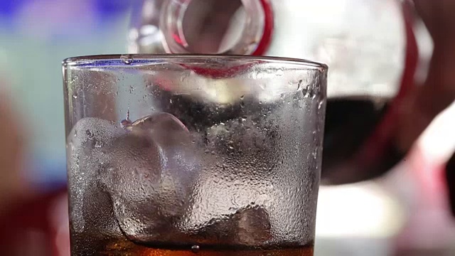 近距离的人的手倒或填补冷饮苏打冰镇在玻璃杯，小DOF的清爽气泡苏打汽水