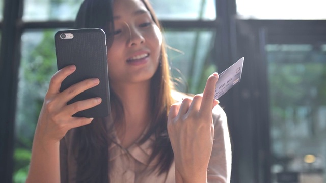 詳情圖-年輕的亞洲女人用信用卡在手機(jī)上購物