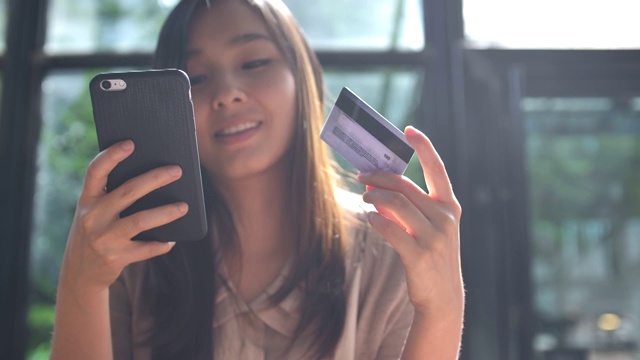 詳情圖-年輕的亞洲女人用信用卡在手機(jī)上購物