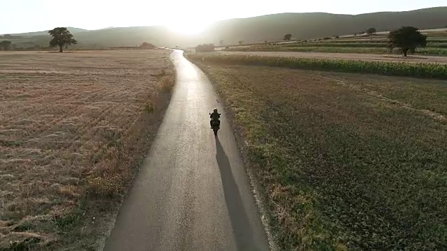 无人机视角下的男人在路上骑摩托车