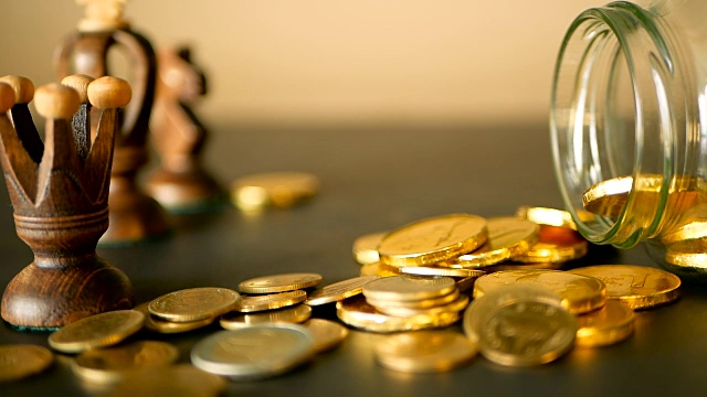 詳情圖-特寫靜物生活與黃金在黑色的桌子上，象棋和旋轉(zhuǎn)便士。黃色的硬幣從罐子里掉了出來。