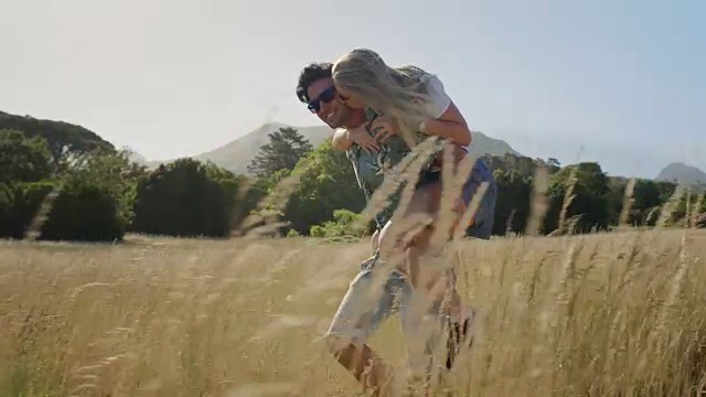 詳情圖-騎在背上的情侶笑在長長的草地上相愛