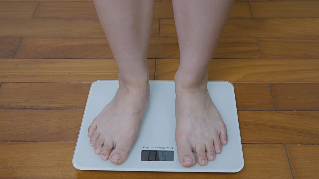 称完体重后，年轻女性表现出积极的情绪和微笑