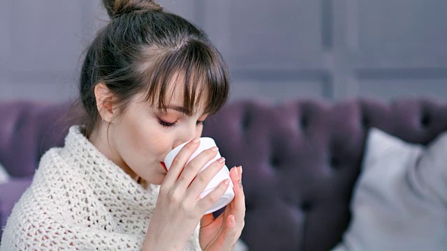 特写肖像浪漫的家庭年轻女子喝热饮杯包裹在格子