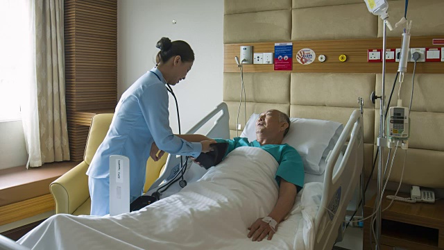 亚洲护士在医院检查老人血压的实时视频