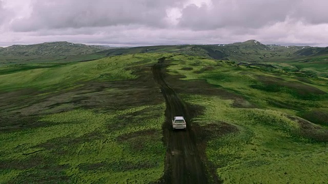 详情图-空中跟踪拍摄的银色4x4越野车行驶在山顶的山路