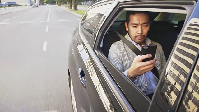 商人在使用智能手机的同时乘坐优步穿越城市