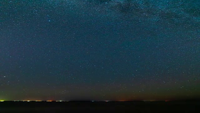 城市灯光背景下的星空。时间流逝