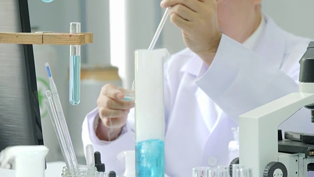在实验室里通过显微镜观察医学研究的科学家