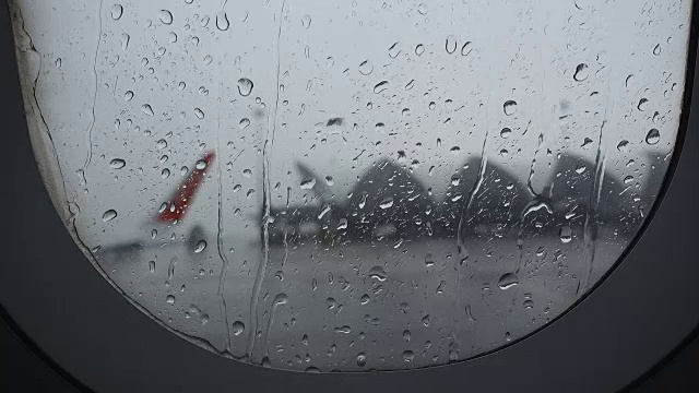 从机场窗口拍摄的下雨航班延误照片