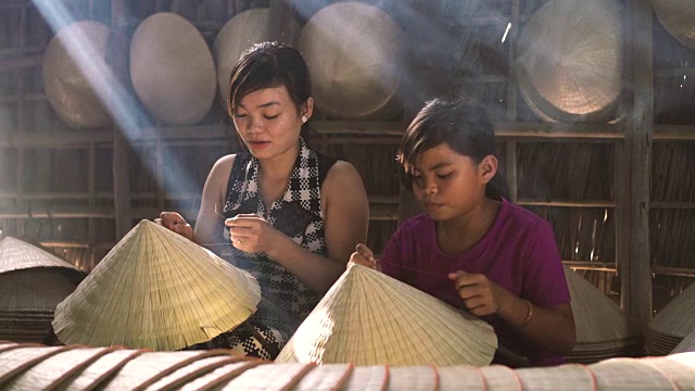 详情图-两名同胞越南工匠在老传统房子制作传统越南帽子的4k镜头低光场景，在Ap,Thoi,Phuoc村，Cantho省，越南，传统艺术家的概念