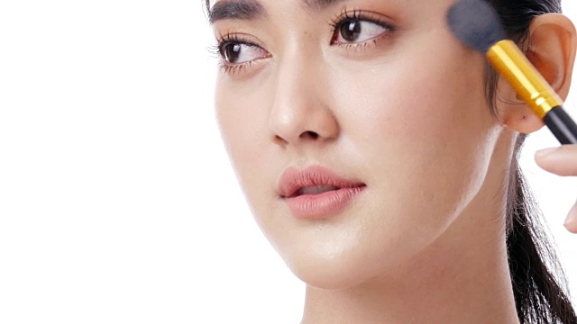 詳情圖-亞洲美麗的女人使用刷子化妝她的臉在白色的背景。人具有美容、化妝、保健的理念。