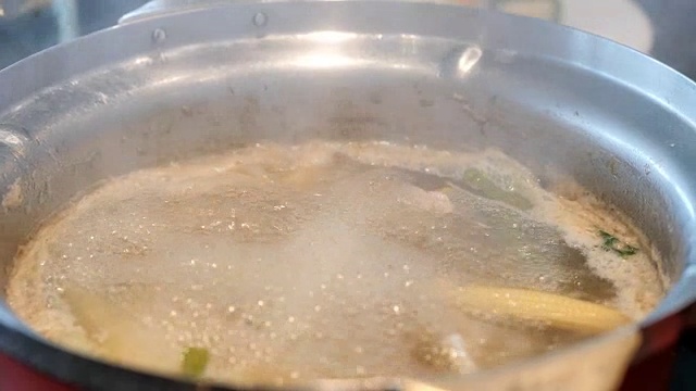 在电锅中煮Suki或Shabu与萝卜，牵牛花，猪排，鱿鱼，玉米，粉丝和猪肉。视频慢动作