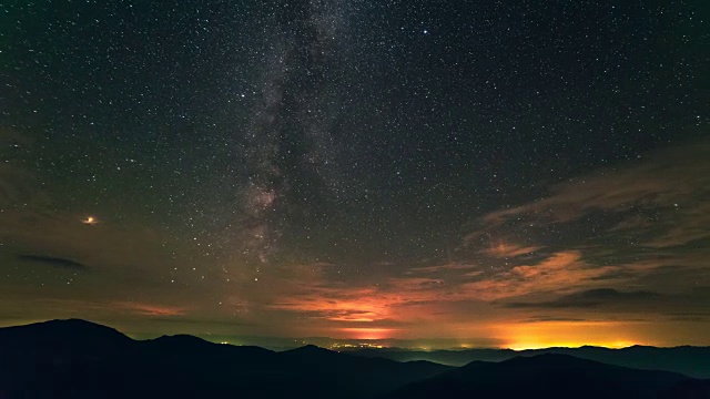 在星空的背景上，云在群山之上流动。时间流逝