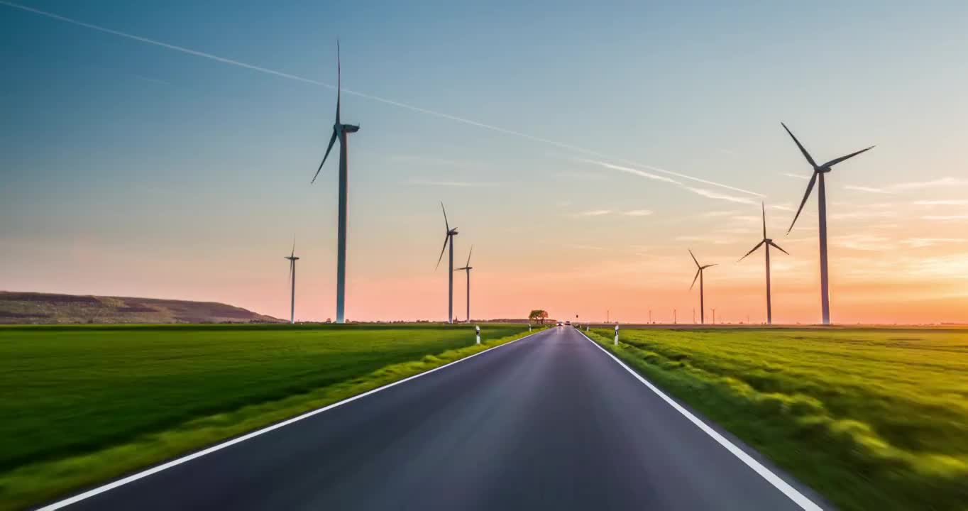 在被风力涡轮机包围的道路上驾驶