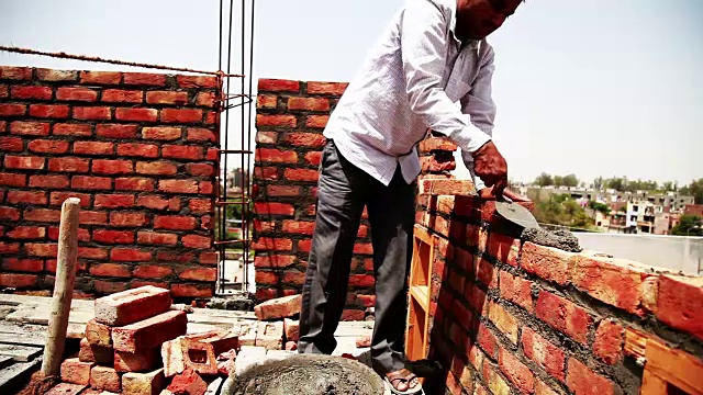 砌砖工正在建筑工地上安装砖