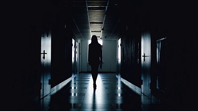 詳情圖-女商人的剪影沿著走廊走。