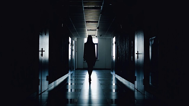 詳情圖-女商人的剪影沿著走廊走。
