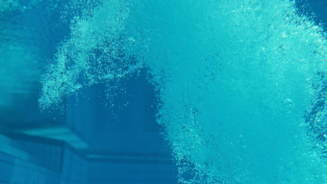 SLO MO LD高潜水员做一个水下翻转时，击中游泳池
