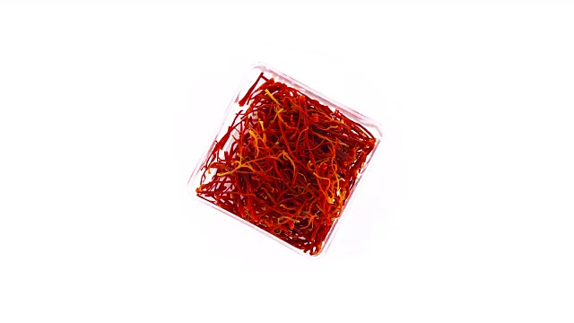 俯视图从上面的透明盒高质量红色藏红花线。慢慢旋转在转盘上孤立的白色背景。关闭了。宏。