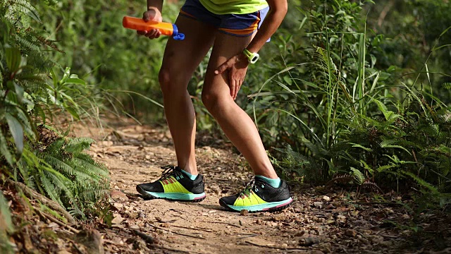 健身亚洲女性越野跑步者在森林山越野跑步前涂抹防晒霜尖叫乳液