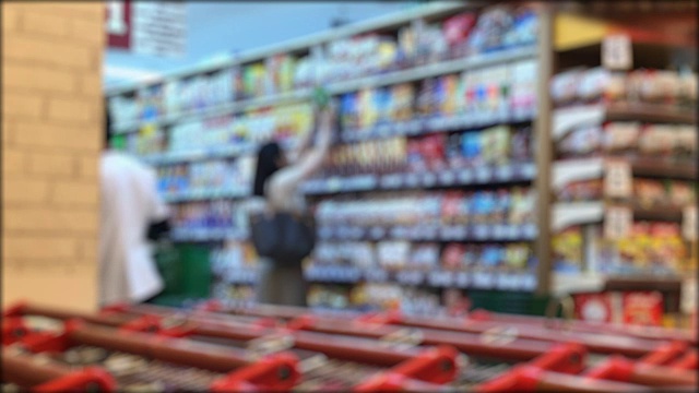模糊的女人在商店的货架上挑选商品