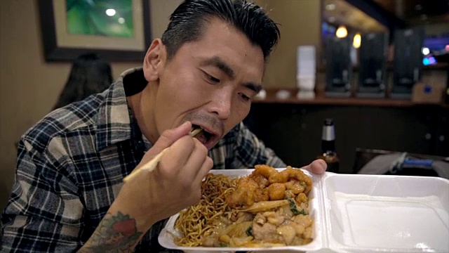 纹身亚洲男人吃中餐外卖
