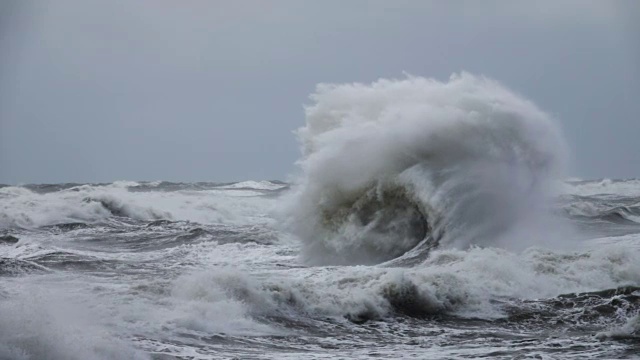 海浪拍打着海岸线上的岩石。巨浪粉碎海岸，大海美丽的海浪。超级慢动作。