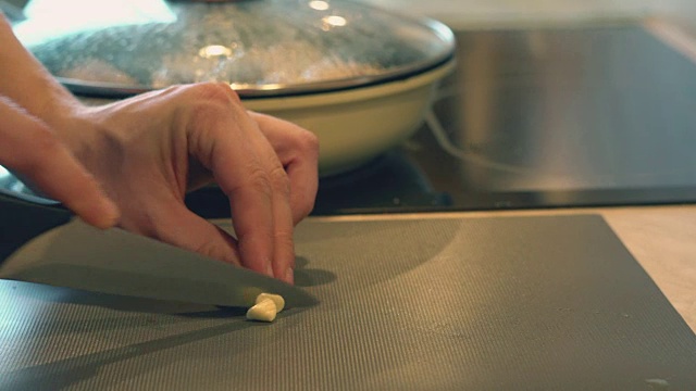父亲穿着格子衬衫在家里的厨房里为他的孩子们做晚餐的鸡腿