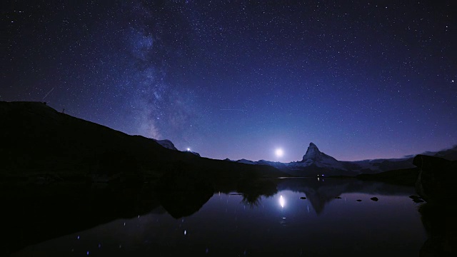 美丽的天空4K时间的流逝马特洪峰金字塔的颜色与银河和所有的星星在斯特利斯湖。在瑞士阿尔卑斯山，泽马特，瑞士，欧洲的伟大的反射夜景